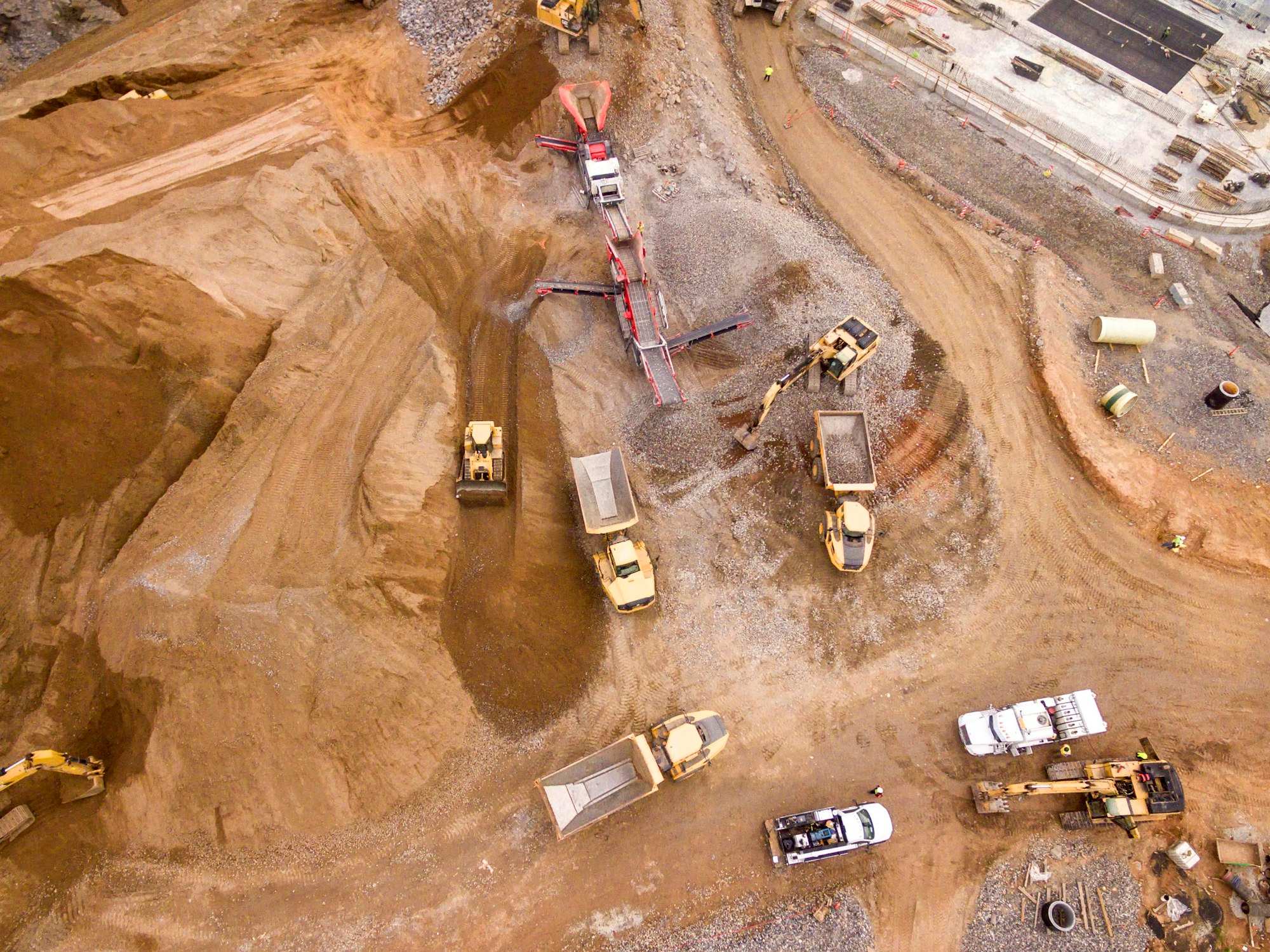 Aerial view of dump trucks on red earth at a mine
